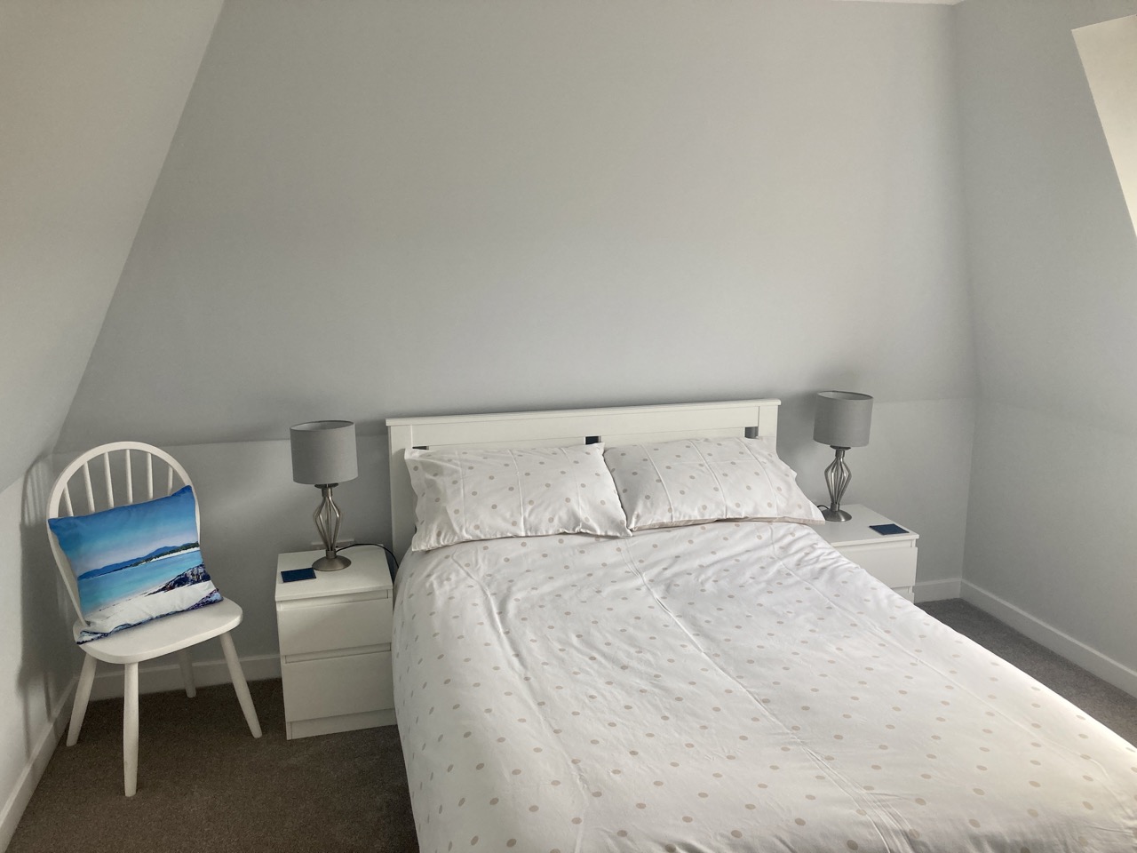 Double bedroom with timber ceiling and soft natural light